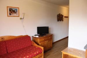 a living room with a couch and a television at Les Chalets De Superd Ancolie - APPARTEMENT DANS CHALET DE 30 LOGEMENTS EXPO VALLEE MAE-8434 in Le Dévoluy