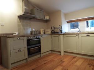 a kitchen with white cabinets and a stove top oven at The Stableyard in Bedford