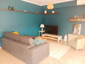 a living room with a couch and a tv at Lazarus 2BD Apartment in the Center in Patra