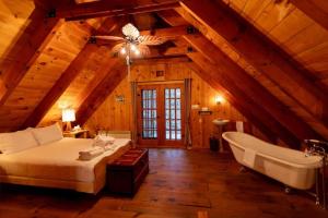 um quarto com uma cama e uma banheira num sótão em Bois Rond Sauna Lake em Grenville-sur-la-Rouge