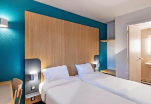 a bedroom with two beds and a blue wall at B&B HOTEL Quimper Nord Douarnenez in Quimper
