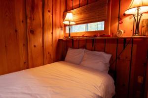 um quarto com uma cama branca com duas luzes em Bois Rond Sauna Lake em Grenville-sur-la-Rouge