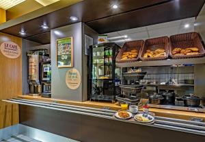 a bakery with a counter with pastries and food at B&B HOTEL Quimper Nord Douarnenez in Quimper