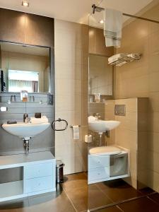 ein Badezimmer mit 2 Waschbecken und einem Spiegel in der Unterkunft Skol l'Original in Luxemburg (Stadt)