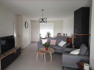 a living room with a couch and a table at Chez Jeannine et Yvo in Mai Cornet