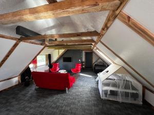 um quarto no sótão com um sofá vermelho e uma cama em Family Apartment - Near Billund em Randbøldal