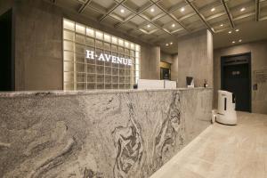a lobby with a large marble counter in a building at H Avenue Hotel Sangmu Branch in Gwangju