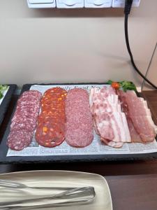 a tray with different types of meat and vegetables at Villa Dunaj in Dunajská Streda