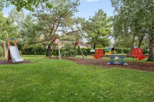 un parque con 2 columpios y un parque infantil en La Résidence du Golf - maeva Home - Appartement 2 pièces 4 personnes - Conf 38, en Deauville