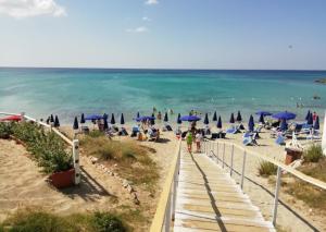 a beach with chairs and umbrellas and the ocean at l'alba sullo jonio in Taranto