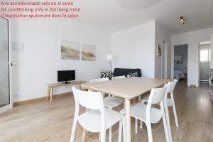カンブリルスにあるUHC Acacias Apartmentsのダイニングルーム(木製テーブル、白い椅子付)