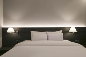 Postel nebo postele na pokoji v ubytování H Avenue Hotel Sangmu Branch