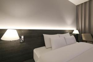Postel nebo postele na pokoji v ubytování H Avenue Hotel Sangmu Branch