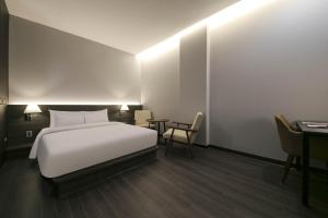 Postel nebo postele na pokoji v ubytování H Avenue Hotel Sangmu Branch