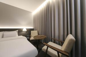 Postel nebo postele na pokoji v ubytování H Avenue Hotel Sangmu Branch