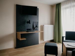 uma sala de estar com uma televisão na parede em Alpengasthof Hochberg - Familie Gruber em Traunstein