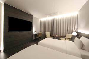 Postel nebo postele na pokoji v ubytování H Avenue Hotel Sangmu Branch