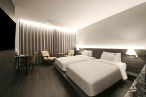 Postel nebo postele na pokoji v ubytování H Avenue Hotel Sangmu Branch