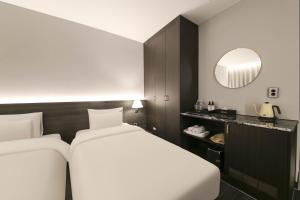 Postel nebo postele na pokoji v ubytování H Avenue Hotel Sangmu Branch