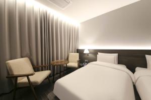 Postel nebo postele na pokoji v ubytování H Avenue Hotel Sangmu Branch