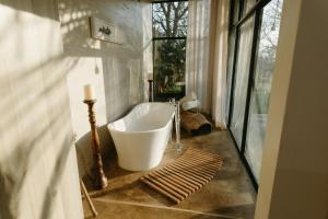 Sensiri Plains Safari Lodge في Mkuze: حمام مع حوض كبير ونافذة