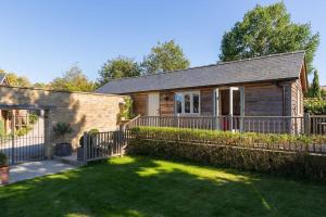 a house with a fence in front of a yard at Charming Cottage surrounded by Idyllic garden in peaceful location in central Charlbury in Charlbury