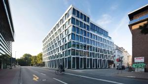 a person riding a bike in front of a building at ATLANTIC Hotel Münster in Münster