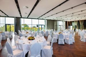a banquet hall with white tables and white chairs at ATLANTIC Hotel Münster in Münster