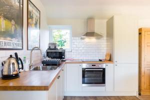 uma cozinha com um lavatório e um fogão forno superior em Charming Cottage surrounded by Idyllic garden in peaceful location in central Charlbury em Charlbury