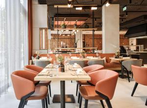 a dining room with tables and chairs and a restaurant at ATLANTIC Hotel Münster in Münster