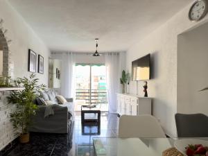 a living room with a couch and a table at Amazing 3-bedroom apartment. Pool and sea view! in Los Cristianos