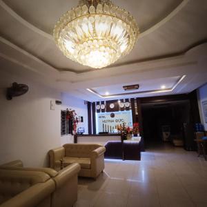 uma grande sala de estar com um grande lustre em Huynh Duc Hotel em Cao Lãnh