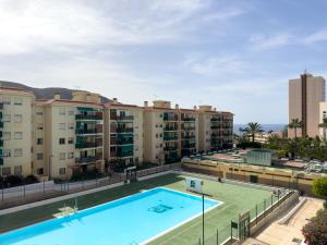 an apartment with a swimming pool and buildings at Amazing 3-bedroom apartment. Pool and sea view! in Los Cristianos
