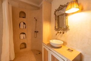 a bathroom with a sink and a shower with a mirror at The Gardener's House, Petit déjeuner inclus in Marrakesh