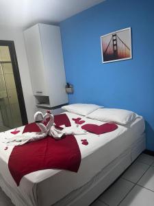 um quarto com uma cama com dois cisnes em Pousada Quaraçá Maceió Pajuçara em Maceió