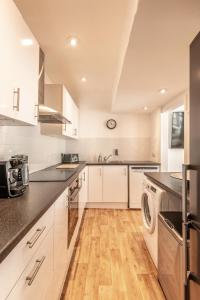 a kitchen with white cabinets and a washer and dryer at Brighton & Hove Beach - group or family fun in Brighton & Hove