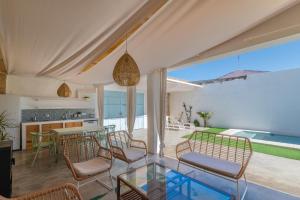 sala de estar con mesa de cristal y sillas en La casa de los marqueses, en Villanueva del Ariscal