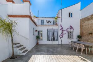 un patio de un edificio con mesa y sillas en La casa de los marqueses, en Villanueva del Ariscal