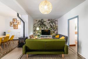 a living room with a green couch and a table at La casa de los marqueses in Villanueva del Ariscal