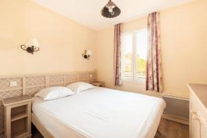 sypialnia z białym łóżkiem i oknem w obiekcie Les Coteaux de Pont Royal en Provence - maeva Home - Maison 4 Pièces 8 Personnes - Sélection MAE-6026 w mieście Mallemort