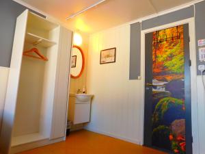 a hallway with a bathroom with a painting on the wall at Skogsro Forest Hostel in Steinsholt