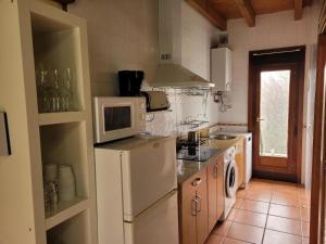 een keuken met een witte koelkast en een magnetron bij La Casa de Trefacio in Trefacio