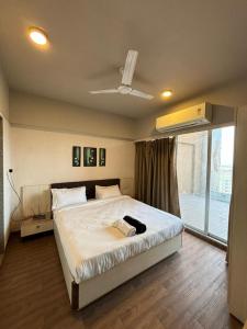 a bedroom with a large bed and a window at Weekend Address By Honest Homes in Surat