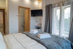 a bedroom with a bed with towels on it at Kostis Orange Resort in Volos