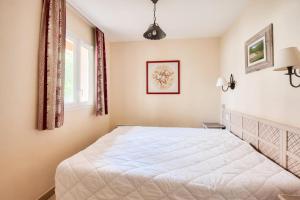 Un dormitorio con una gran cama blanca y una ventana en Les Coteaux de Pont Royal en Provence - maeva Home - Appartement 2 Pièces 4 30, en Mallemort