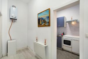 a white kitchen with a painting on the wall at Cristobal y concha in Las Palmas de Gran Canaria