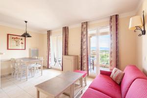 een woonkamer met een rode bank en een tafel bij Les Coteaux de Pont Royal en Provence - maeva Home - Appartement 2 Pièces 4 17 in Mallemort