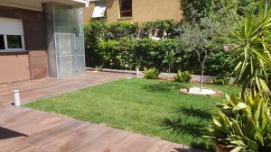a backyard with a yard with grass and a house at Residence Appartamenti Casa Vacanze Abbazia in Pesaro