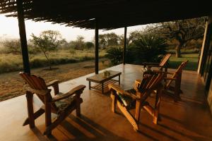 Sensiri Plains Safari Lodge في Mkuze: مجموعة من الكراسي وطاولة على الشرفة