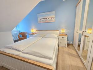 ein Schlafzimmer mit einem großen Bett mit einer blauen Wand in der Unterkunft Dünenpark Binz - Klassik Ferienwohnung mit 1 Schlafzimmer und Balkon im Dachgeschoss 184 in Binz